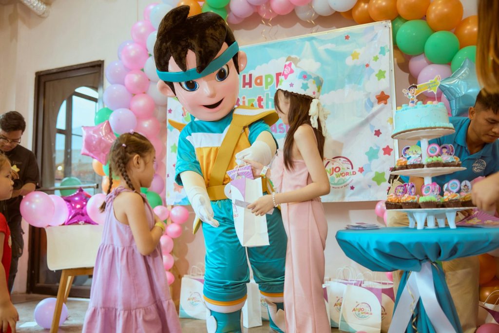 Mascot giving gift to girl at birthday party