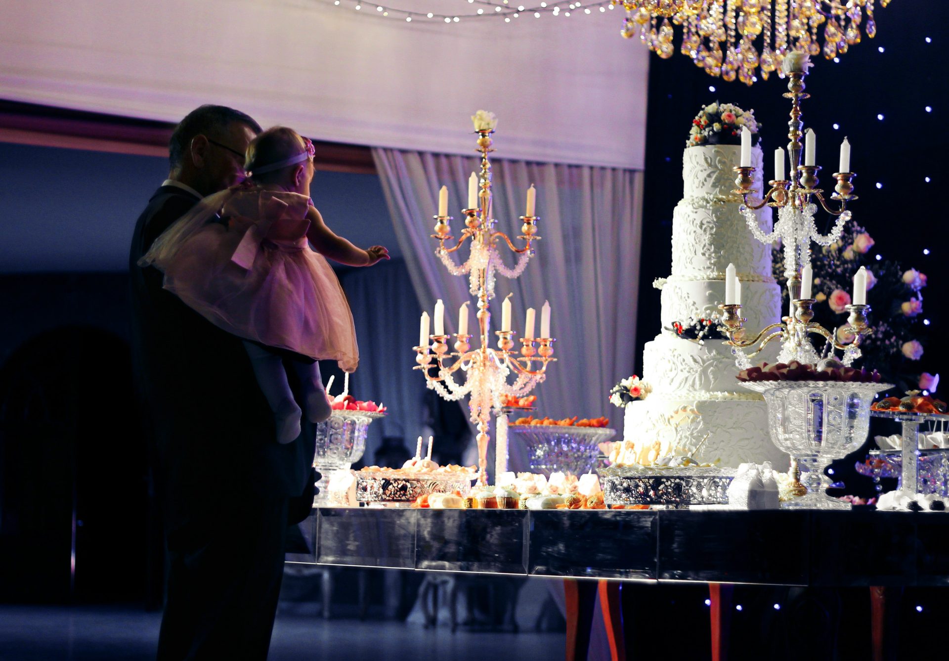 a bride and groom kiss in front of a wedding cake