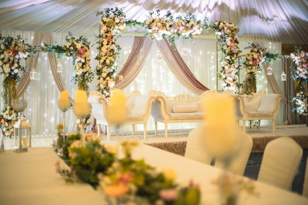 Elegant event stage with floral decor and luxurious seating